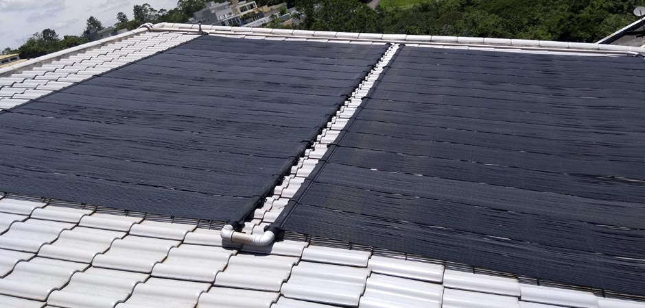 Coletores solar de piscina instalados no telhado. Os coletores captam os raios solares para aquecer a água dentro deles.